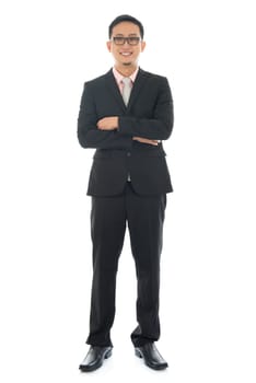 Full length pan Asian businessman crossed arms standing isolated on white background.