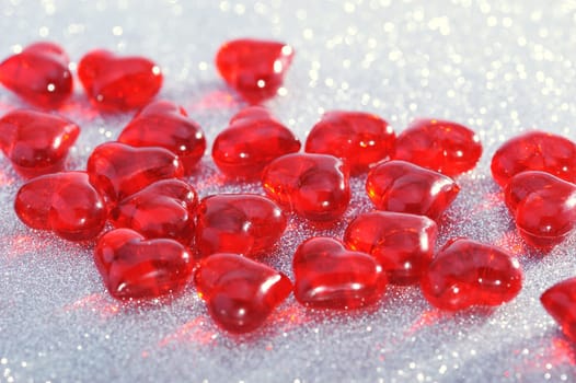 Red glass hearts on silver glitter background