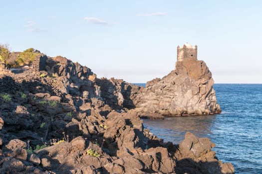Medieval Tower build on lava stone in ionian sea Sicily