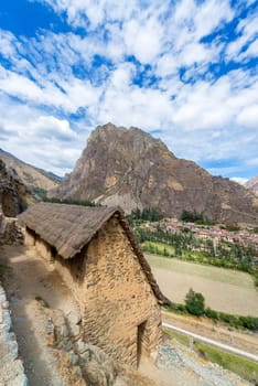 Inca ruins with a thatched roof in Ollantaytambo, Peru