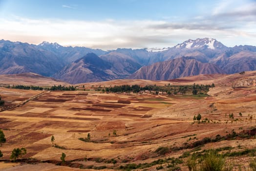 View of fields in the Sacred Valley near Cusco, Peru with Andes mountains rising over it