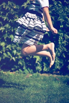 Little girl jumps. Exterior shot.