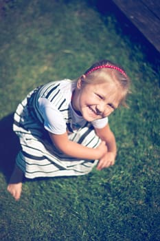 the little girl sitting on the grass