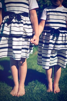 Girls holding hands. Exterior shot.