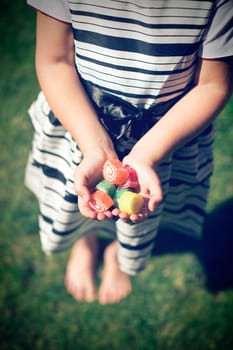 Little girl with candy in hands. Exterior shot.
