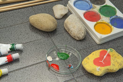 Handmade - stone painting. Requirements for painting on stone are laid out on the table.