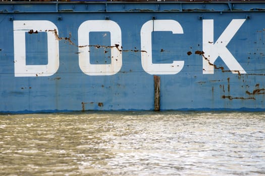 The furrowed and scratched photograph of the steel wall of a dock in the port of Hamburg.