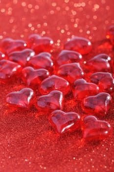 Red glass hearts on a red glitter background