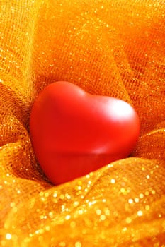 Red heart on golden glitter background
