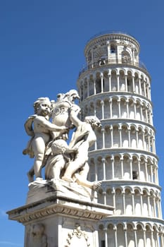 Statue And Leaning Tower Of Pisa (Italy). Vrtically. Blue sky in the background.