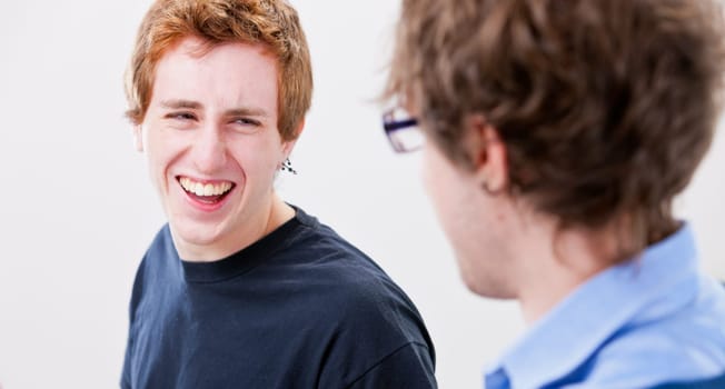 a young masculine man smiles or laughs because of a great success