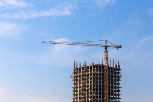 Construction crane on building site on sky background