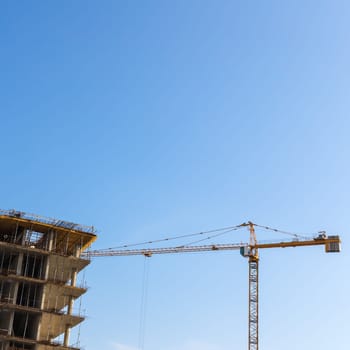 Construction crane on building site on sky background