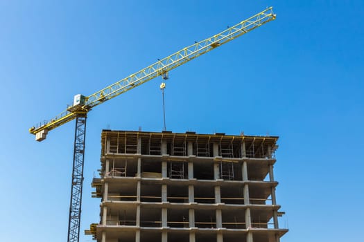 Construction crane on building site on sky background
