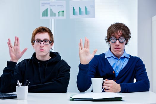 a couple of nerd office workers showing a very popular science fiction salutation