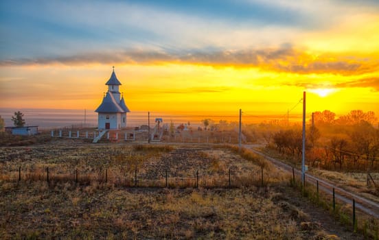 Landscape of the church in a small village in Romania at sunrise.