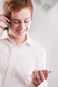 a happy geek fan of mobile phones calling with two cellular phones