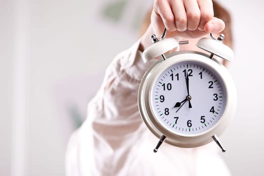 a red headed clerk showing off an alarm clock