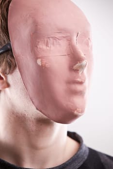 a young man disguised behind a pink mask