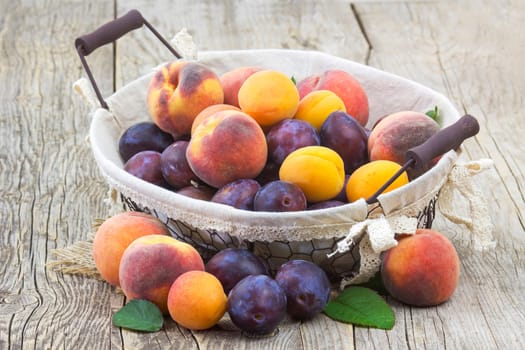 fresh fruits in a basket on wooden background