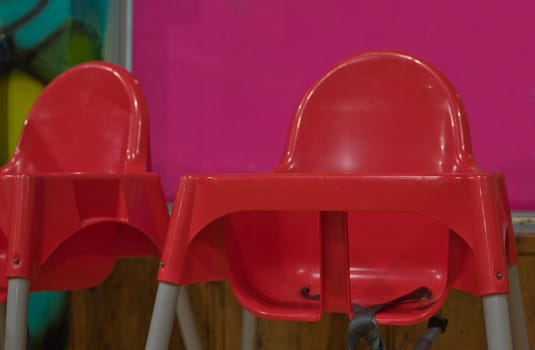 Red plastic dinning baby chairs with seat belts