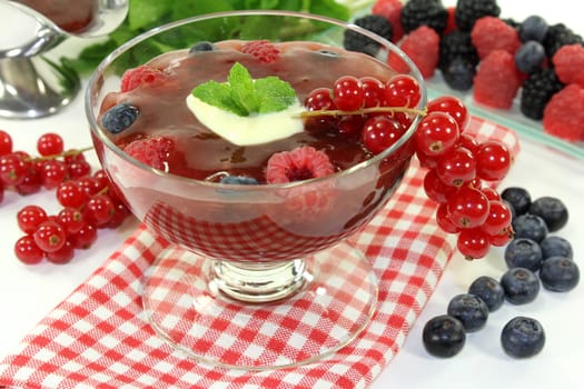 a glass with red grits,vanilla sauce and mint