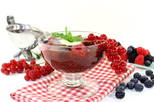a glass with red grits,vanilla sauce and mint