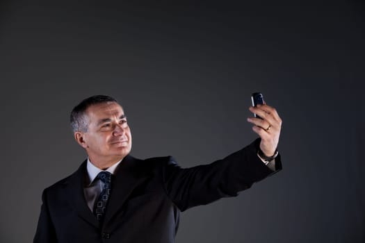A senior manager using successfully his inseparable smartphone agenda and calendar, now taking a selfie
