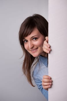 Nice girl showing up behind the white wall