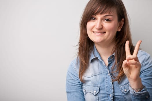 ordinary successful girl showing off fingers of victory
