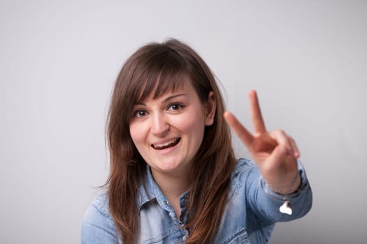 ordinary successful girl showing off fingers of victory