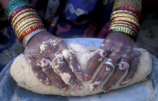 a women is making Bread in the town of Jaisalmer in the province of Rajasthan in India.