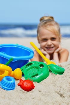 Little girl playing on the sand beach.