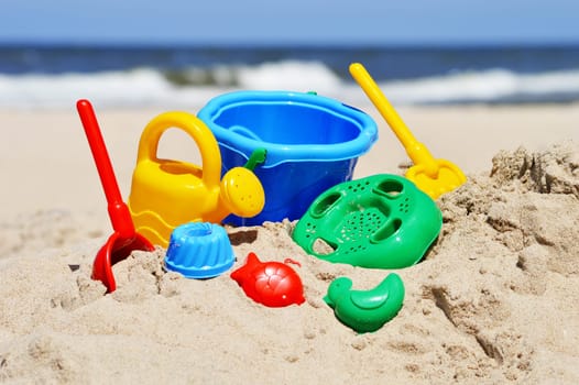 Plastic children toys on the sand beach.