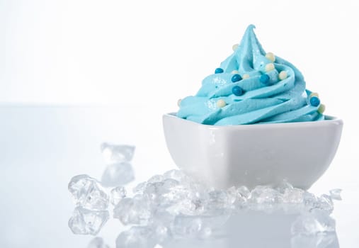 Tasty Colored Frozen Yogurt on White Bowl with ice Cubes on Sides. Isolated on White.
