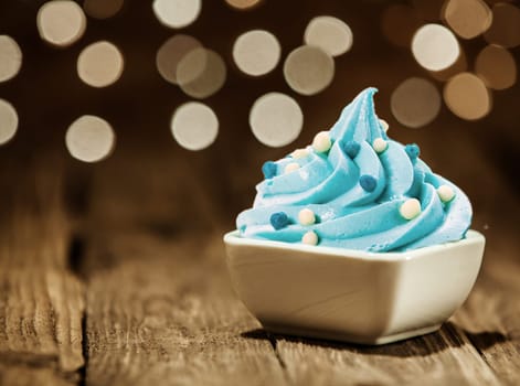 Tasty Sky Blue Frozen Yogurt on White Bowl with Toppings Placed on Wooden Table