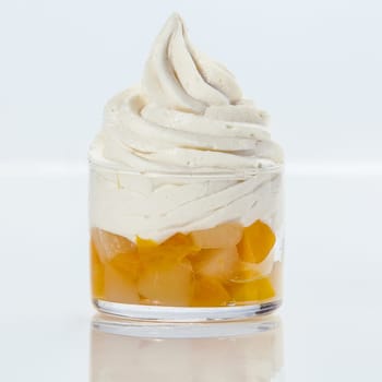 Delicious refreshing twirl of frozen yogurt with fresh fruit salad served in a glass dish on a white background , square format