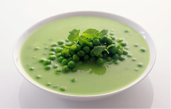 Close up Appetizing Healthy Green Peas Soup on White Bowl Isolated on White Background.