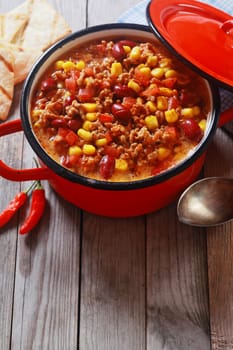Mouth Watering Hot Meaty Dish on Red Pot Placed on Wooden Table Ready to Eat.