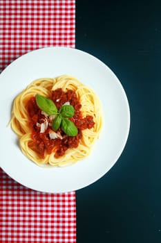 Plate of spaghetti Bolognaise or Bolognese with a rich tomato and ground beef sauce garnished with basil and parmesan cheese