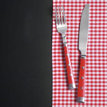 Close up Kitchen Utensils on Red White Checkered Cloth at Black Table.