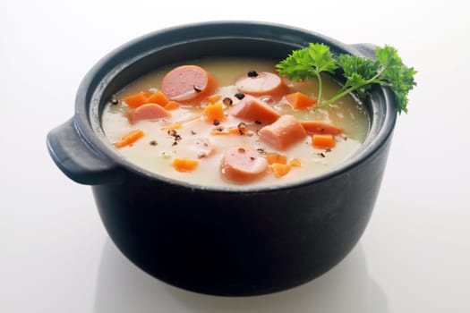 Appetizing Main Course Soup Dish Recipe on Black Pot Isolated on Gray Background.