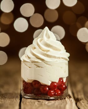Macro Tasty Frozen Yogurt on Round Glass Container with Red Cherries Placed on Wooden Table.