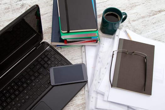 Working, with the laptop, a pile of books, and drinking a coffee.