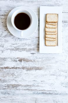 Coffee with crackers on a wooden table.