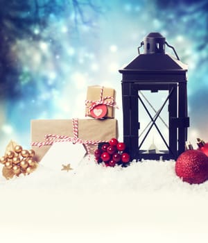 Christmas lantern with ornaments in the snow at night
