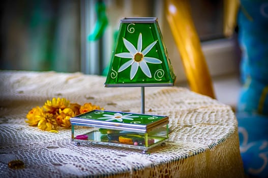 A small tiffany type lamp and casket on the table.