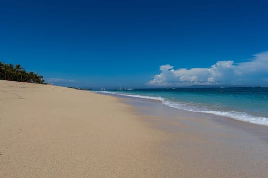 Beautiful secluded sandy beach in the Caribbean with white sand and blue sky as in paradise