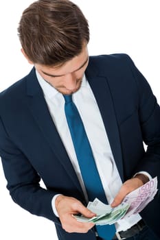 Wealthy successful young businessman with a handful of euro banknotes with a happy smile shows his wealth isolated on white