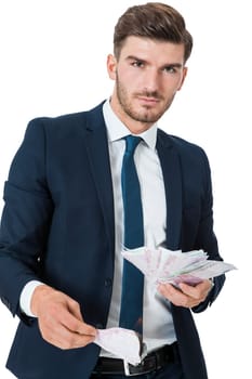 Wealthy successful young businessman with a handful of euro banknotes with a happy smile shows his wealth isolated on white